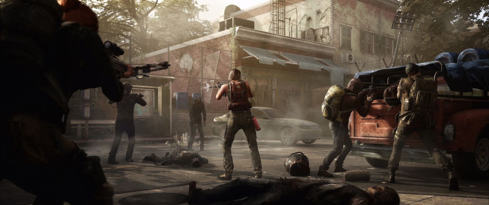A group of survivors holds off the dead in a city street beside a pickup truck.